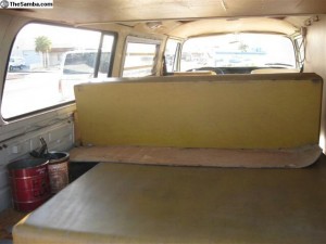 Mustard cushion and bed area in our campervan